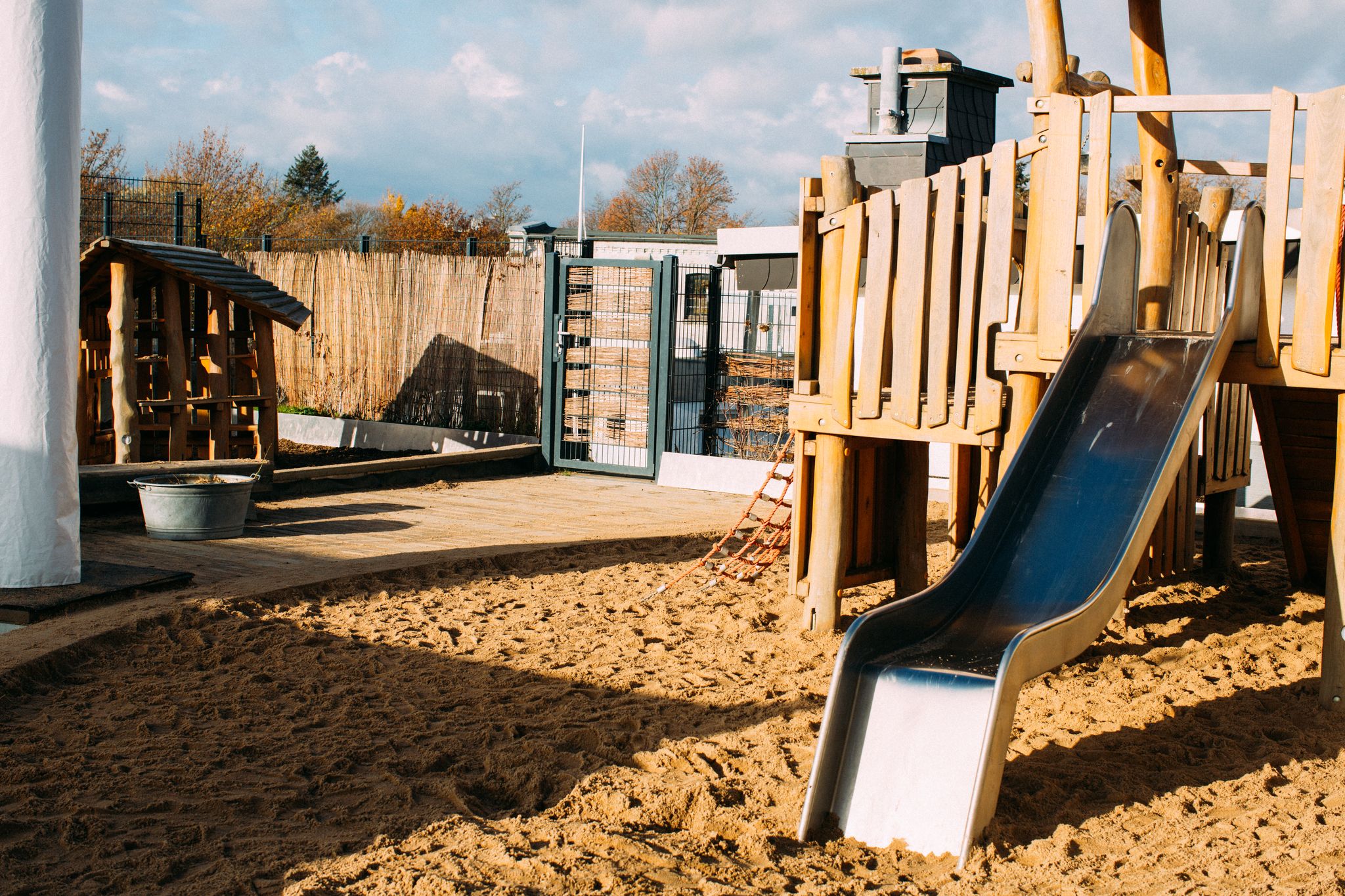 Dachgarten mit einem Klettergerüst, einem Sandbereich und einem Spielhäuschen